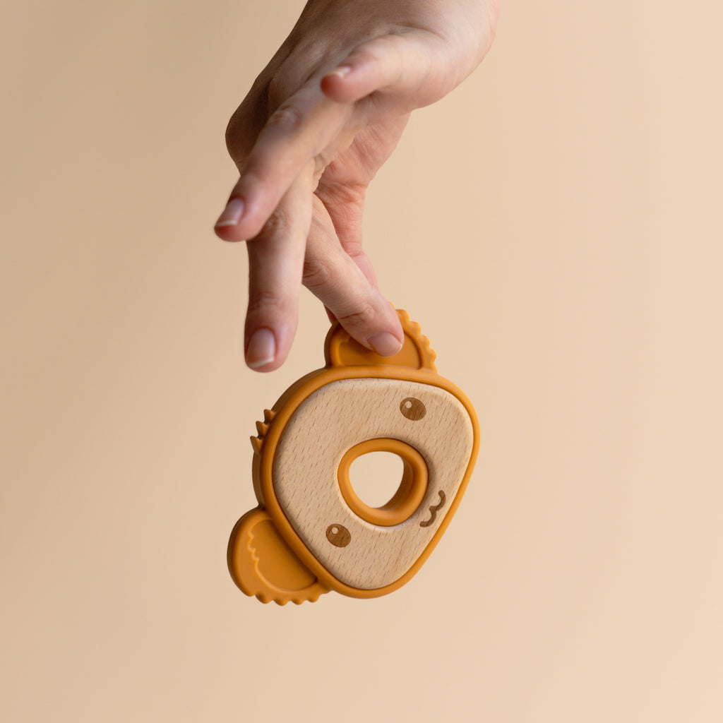 A baby teether like a koalas head, bamboo and silicon, a mother holding it view